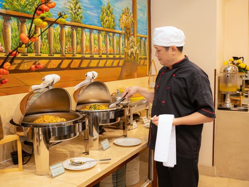 Đầu bếp phục vụ tại quầy buffet bữa sáng