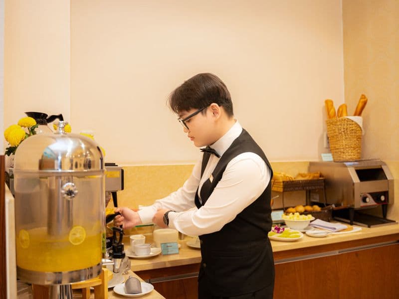 Nhân viên phục vụ nước uống tại quầy bữa sáng