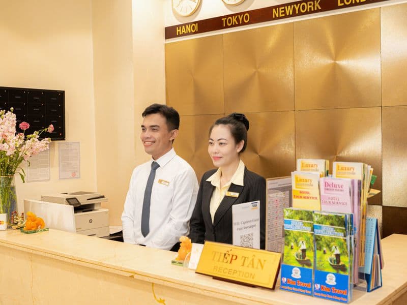 Nhân viên lễ tân chào đón khách tại quầy