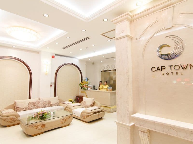 Sảnh khách sạn với bộ sofa, quầy lễ tân và tường logo Cap Town Hotel